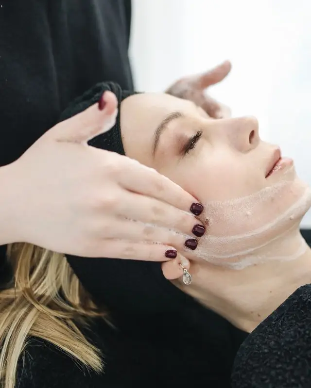 Therapist giving a facial treatment at a spa
