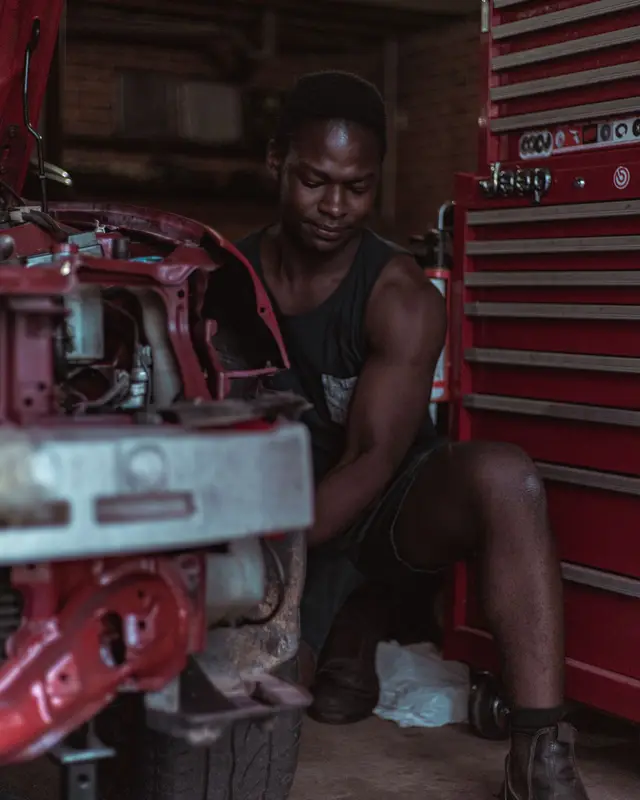 Mechanic working on a car engine in his workshop